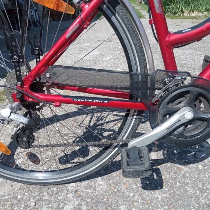 Piros KTM kerékpár hajtása: lánc, lánckerék, hajtókar és hátsó váltó